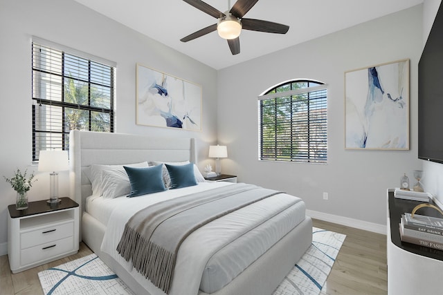 bedroom featuring a ceiling fan, baseboards, and light wood finished floors