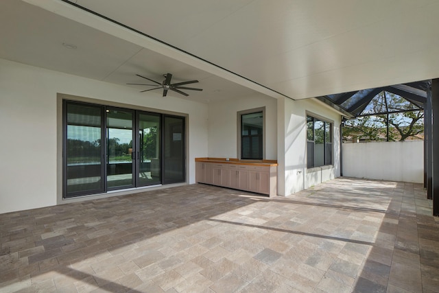 view of patio / terrace with glass enclosure and a ceiling fan