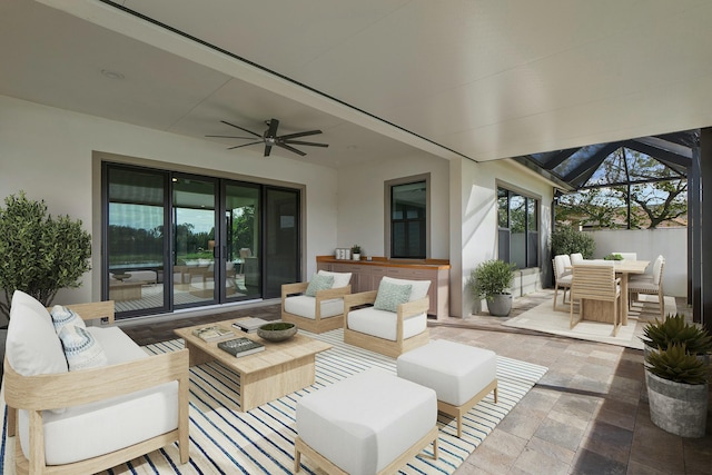 view of patio featuring outdoor dining area, glass enclosure, ceiling fan, and an outdoor living space