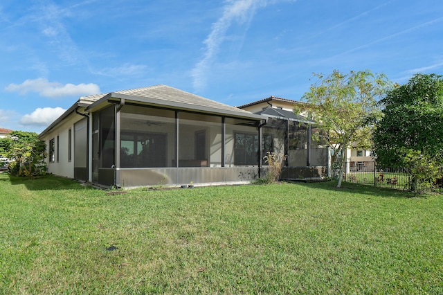 back of house with a tile roof, fence, and a lawn