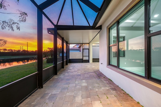 unfurnished sunroom featuring a water view, a skylight, and a wealth of natural light