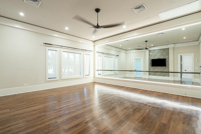 unfurnished living room with ceiling fan, visible vents, and wood finished floors