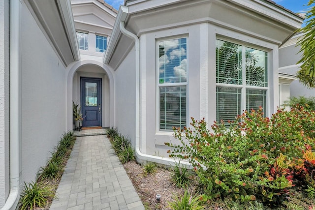 entrance to property featuring stucco siding