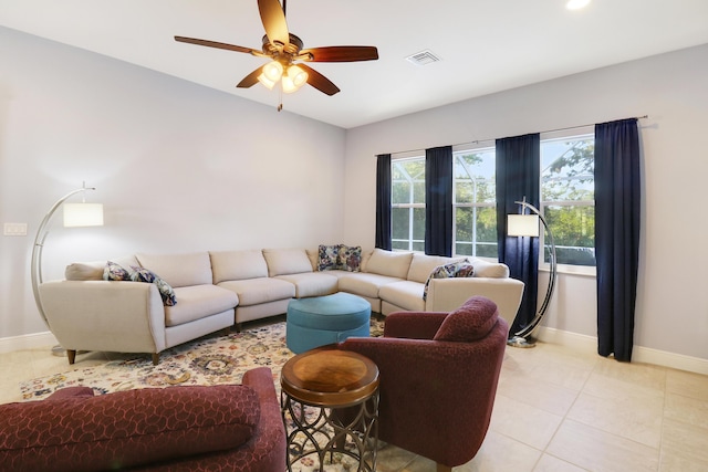 living area featuring light tile patterned floors, baseboards, visible vents, and a ceiling fan