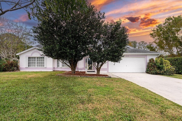 view of front of property featuring a garage, a front lawn, concrete driveway, and stucco siding