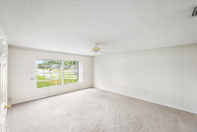 empty room featuring baseboards, visible vents, a ceiling fan, a textured ceiling, and carpet flooring