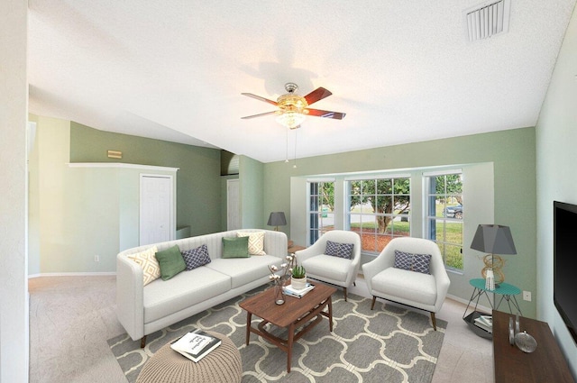 carpeted living room featuring a ceiling fan, visible vents, a textured ceiling, and baseboards