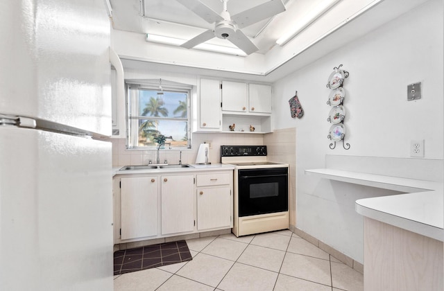 kitchen featuring light tile patterned floors, electric range, a ceiling fan, light countertops, and a sink