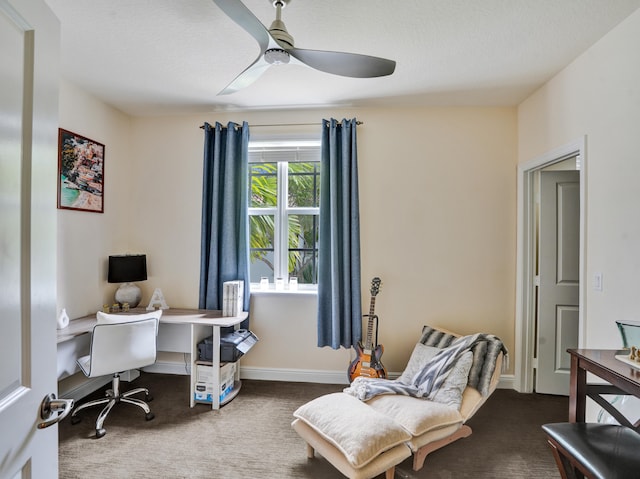 carpeted office space with baseboards and a ceiling fan