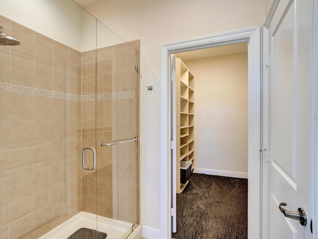 full bath with a stall shower, baseboards, and a walk in closet