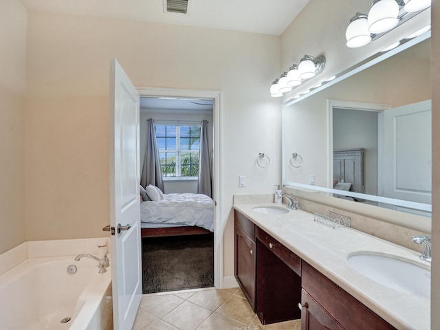 bathroom featuring tile patterned flooring, visible vents, a sink, and a garden tub