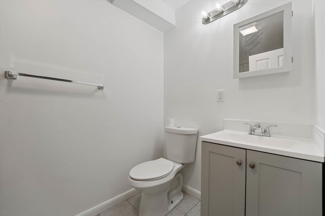 bathroom with toilet, vanity, baseboards, and tile patterned floors