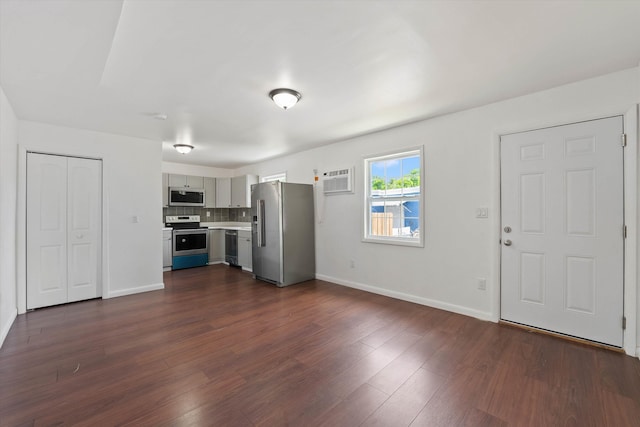 kitchen featuring baseboards, light countertops, appliances with stainless steel finishes, gray cabinets, and dark wood finished floors