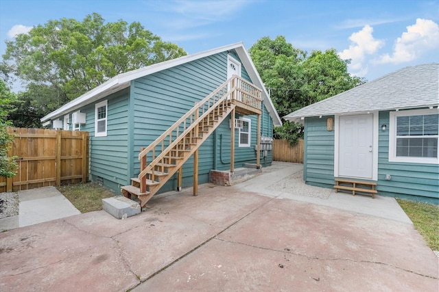 back of house with entry steps, a patio area, fence, and stairs