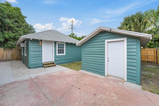 view of outbuilding with fence and an outbuilding