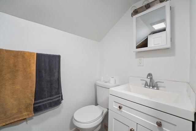 half bath with toilet, vaulted ceiling, and vanity