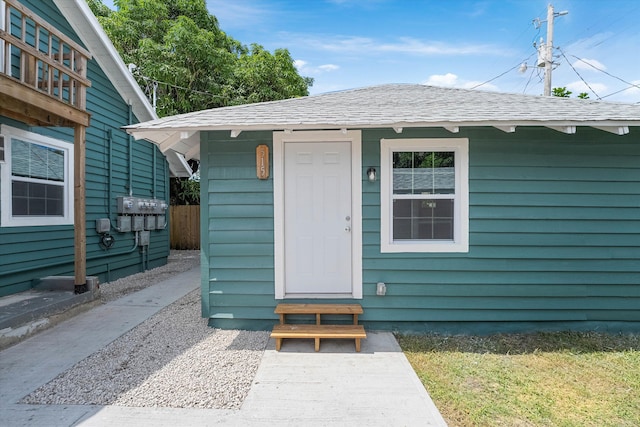 doorway to property featuring a shingled roof