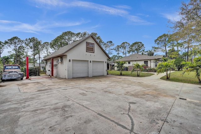 view of property exterior with a garage, a yard, an outdoor structure, and stucco siding