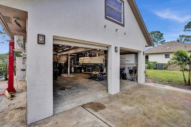 view of patio / terrace featuring a garage, driveway, and cooling unit