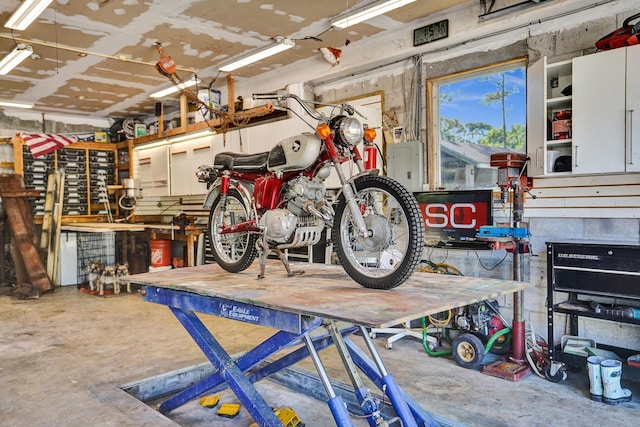 garage featuring electric panel and a workshop area