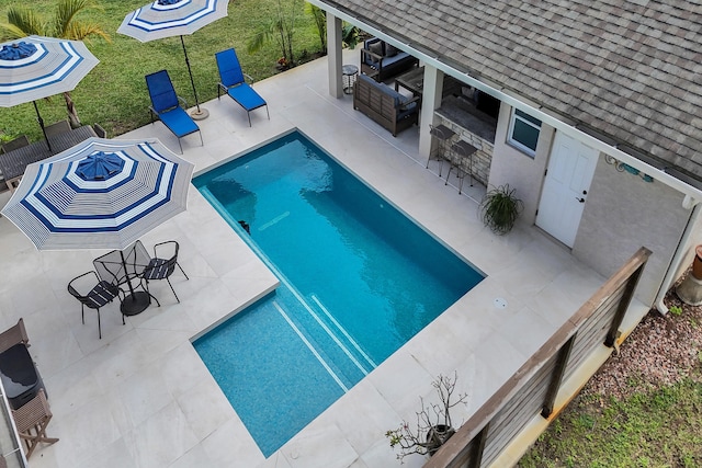 view of pool featuring outdoor dry bar, a patio, an outdoor living space, and a fenced in pool