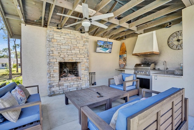 view of patio / terrace with an outdoor living space with a fireplace, area for grilling, a sink, and a ceiling fan