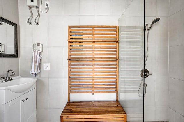 full bathroom with radiator, tile walls, tiled shower, and vanity