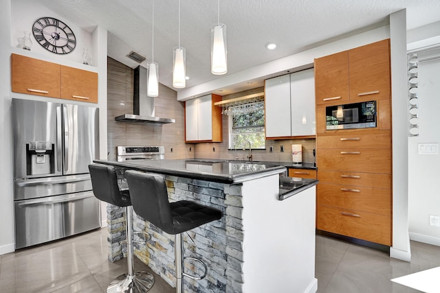 kitchen with a center island, tasteful backsplash, dark countertops, appliances with stainless steel finishes, and wall chimney exhaust hood