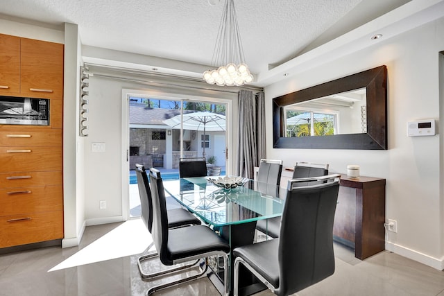 dining area featuring vaulted ceiling, a textured ceiling, plenty of natural light, and baseboards