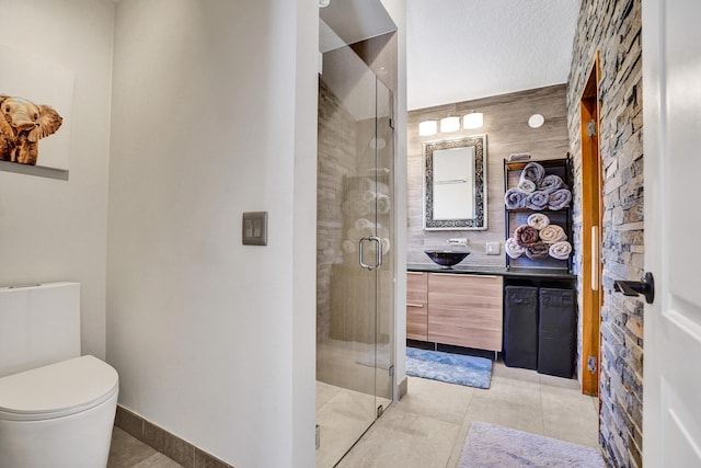 full bathroom featuring a textured ceiling, tile patterned flooring, toilet, vanity, and a stall shower