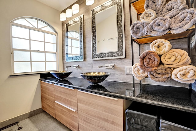 full bath with baseboards, a sink, decorative backsplash, and double vanity