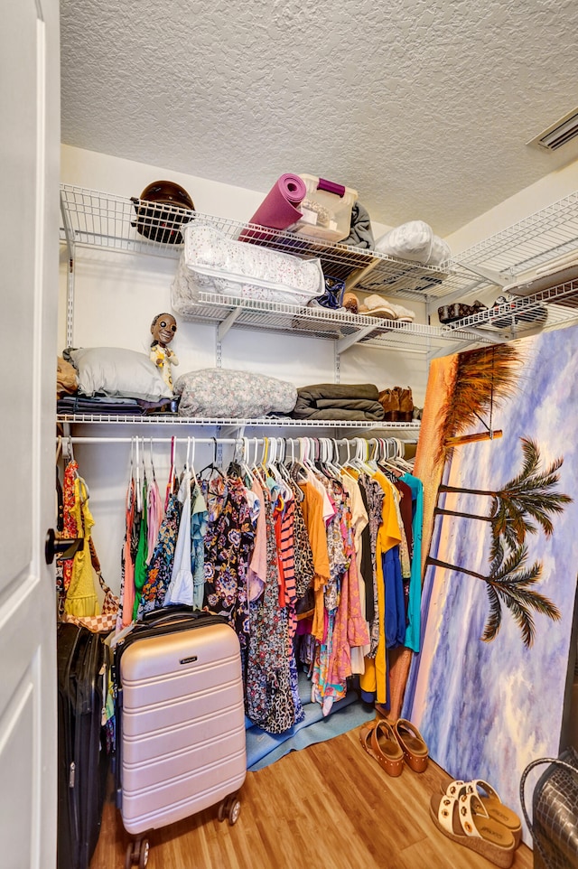 spacious closet featuring visible vents and wood finished floors