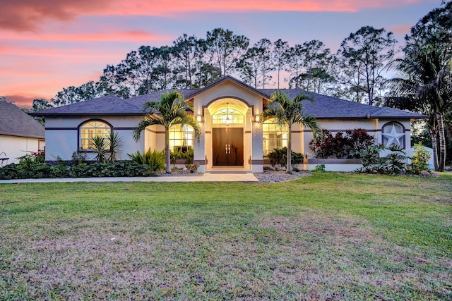 view of front of home with a yard and stucco siding