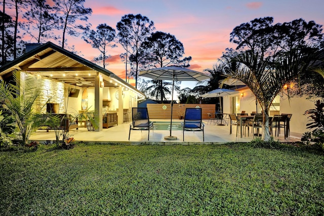 rear view of property with a yard, a patio, stucco siding, fence, and ceiling fan