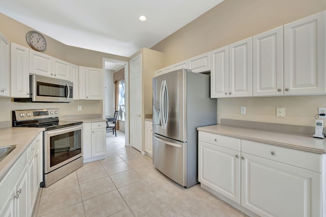 kitchen with light tile patterned flooring, stainless steel appliances, light countertops, white cabinetry, and recessed lighting