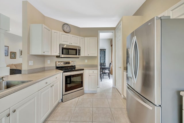 kitchen featuring appliances with stainless steel finishes, white cabinets, light countertops, and light tile patterned floors