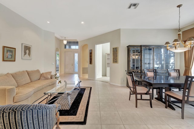 living area featuring arched walkways, light tile patterned floors, recessed lighting, a notable chandelier, and visible vents