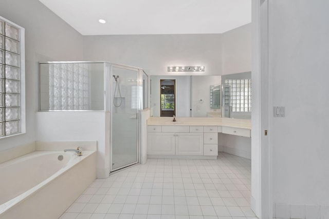 full bathroom with a stall shower, tile patterned flooring, a garden tub, and vanity