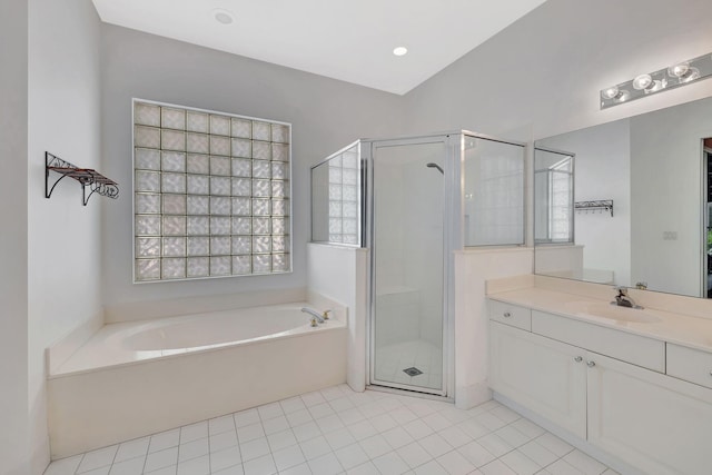 bathroom with a stall shower, tile patterned flooring, a garden tub, and vanity