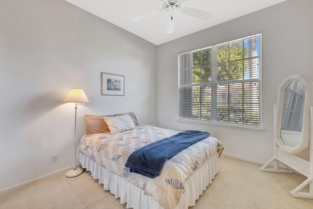 bedroom with light carpet, ceiling fan, and baseboards