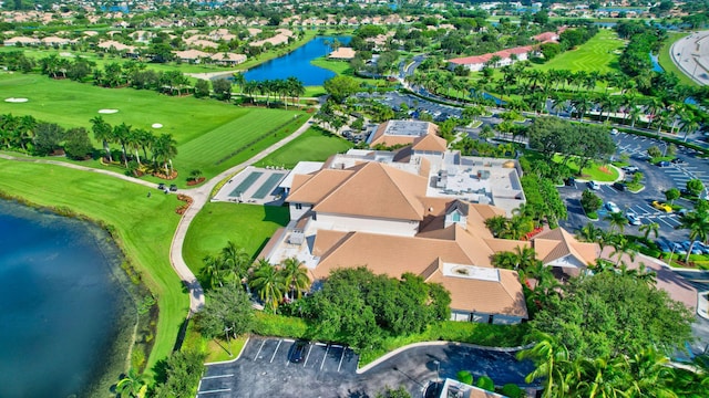 drone / aerial view with a residential view, view of golf course, and a water view