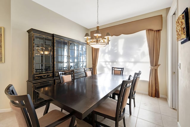 dining area featuring baseboards, light tile patterned floors, and a notable chandelier