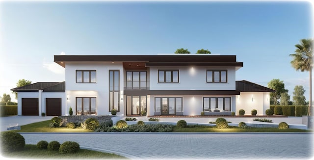 rear view of house featuring french doors, driveway, an attached garage, and stucco siding