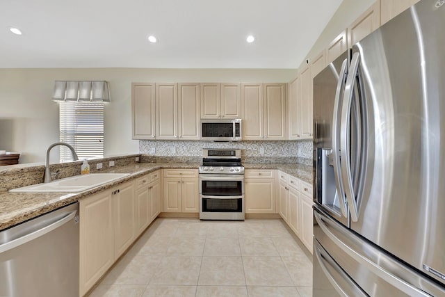 kitchen with light tile patterned floors, tasteful backsplash, stainless steel appliances, and a sink