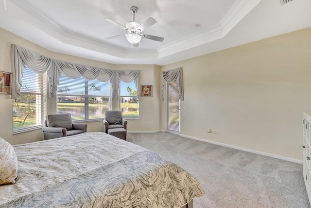 carpeted bedroom with a raised ceiling, crown molding, and baseboards