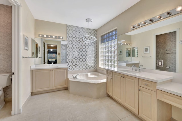 bathroom featuring a garden tub, a sink, toilet, and tile patterned floors