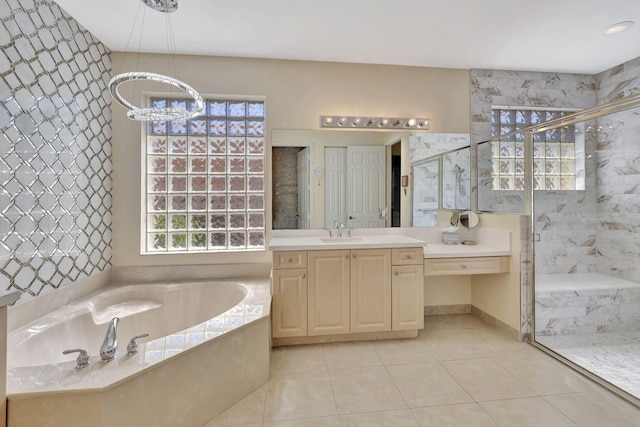 full bathroom with a marble finish shower, a bath, tile patterned floors, vanity, and a notable chandelier