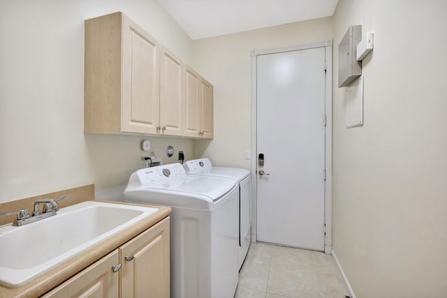 laundry area with cabinet space, baseboards, separate washer and dryer, a sink, and light tile patterned flooring