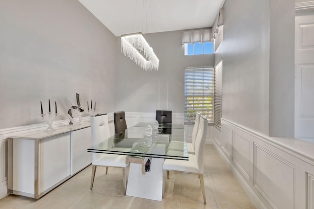 dining room with a chandelier, wainscoting, light tile patterned flooring, and a wealth of natural light