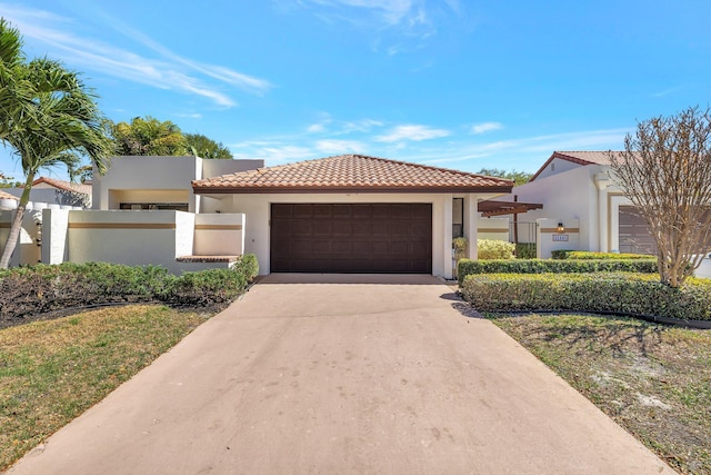 mediterranean / spanish house with a tiled roof, a garage, driveway, and stucco siding